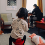 picture of a kid playing while person working